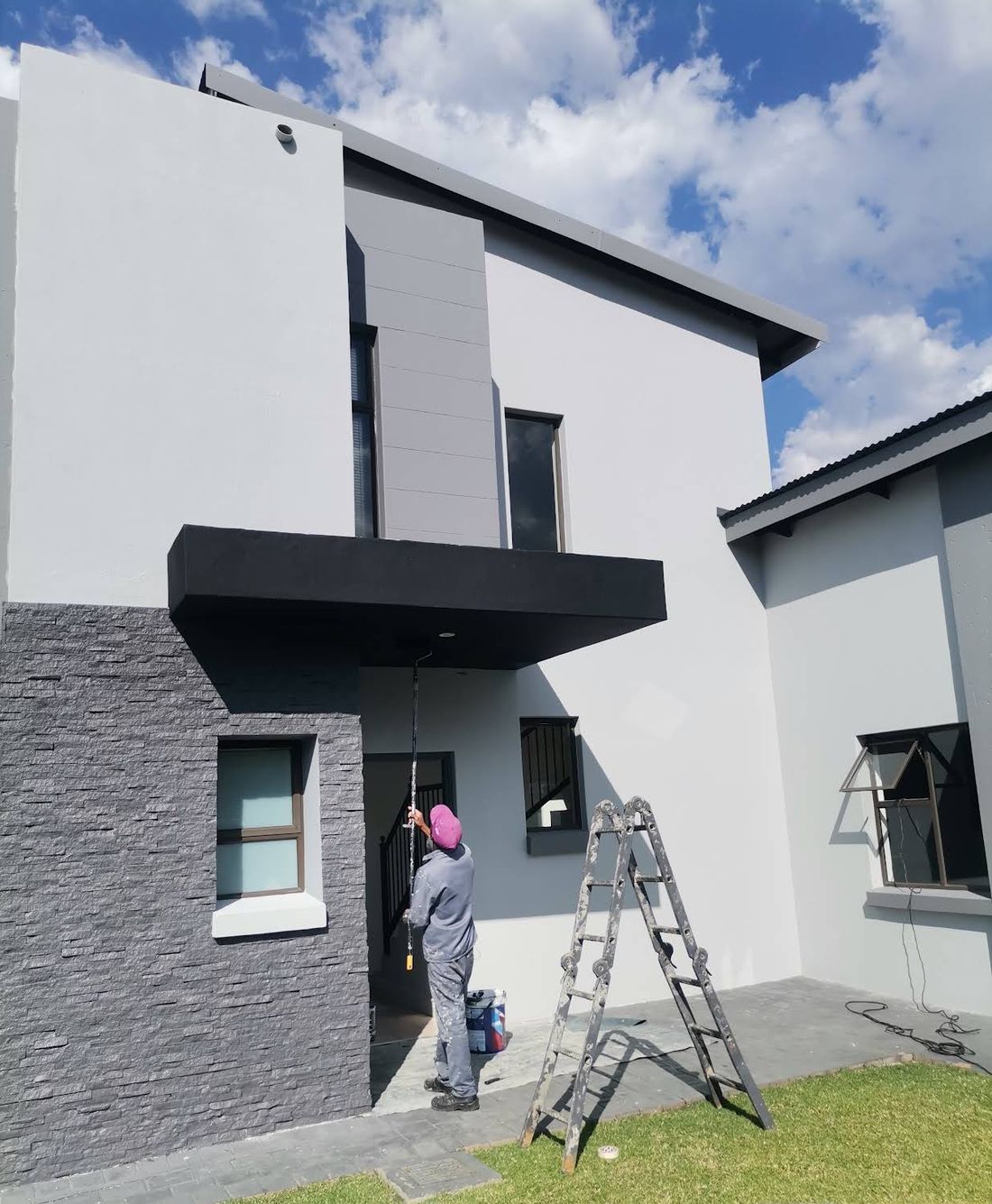 Painter rolling the walls of a double-storey house