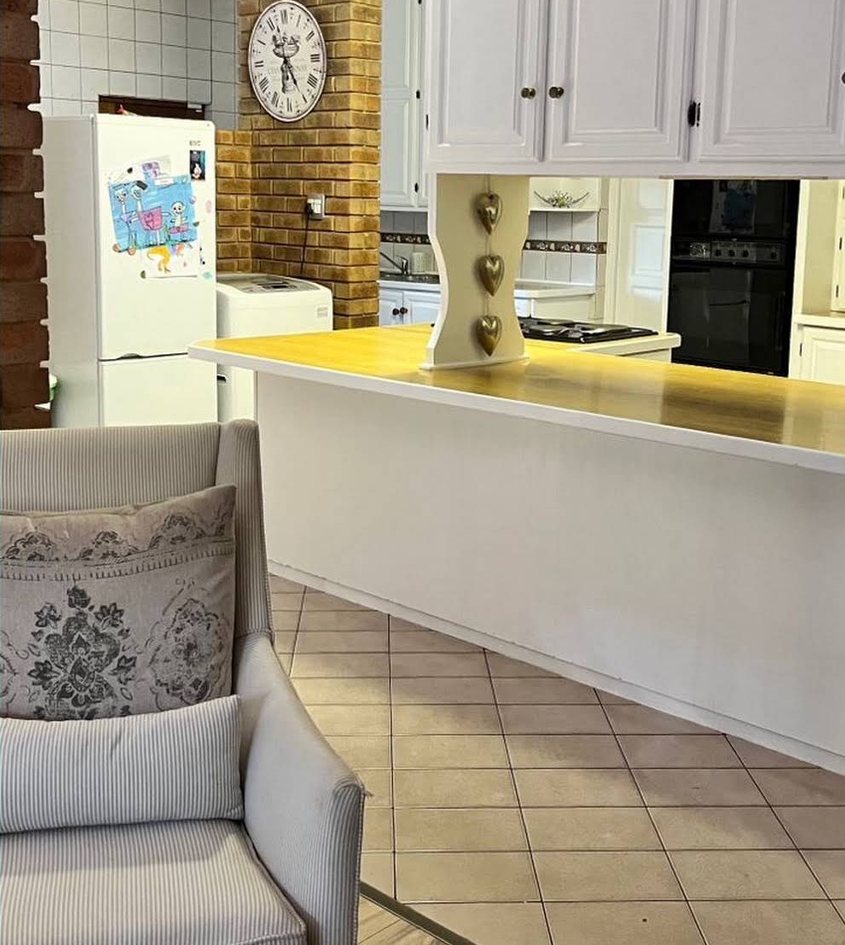After: the same kitchen with white painted cupboards and island