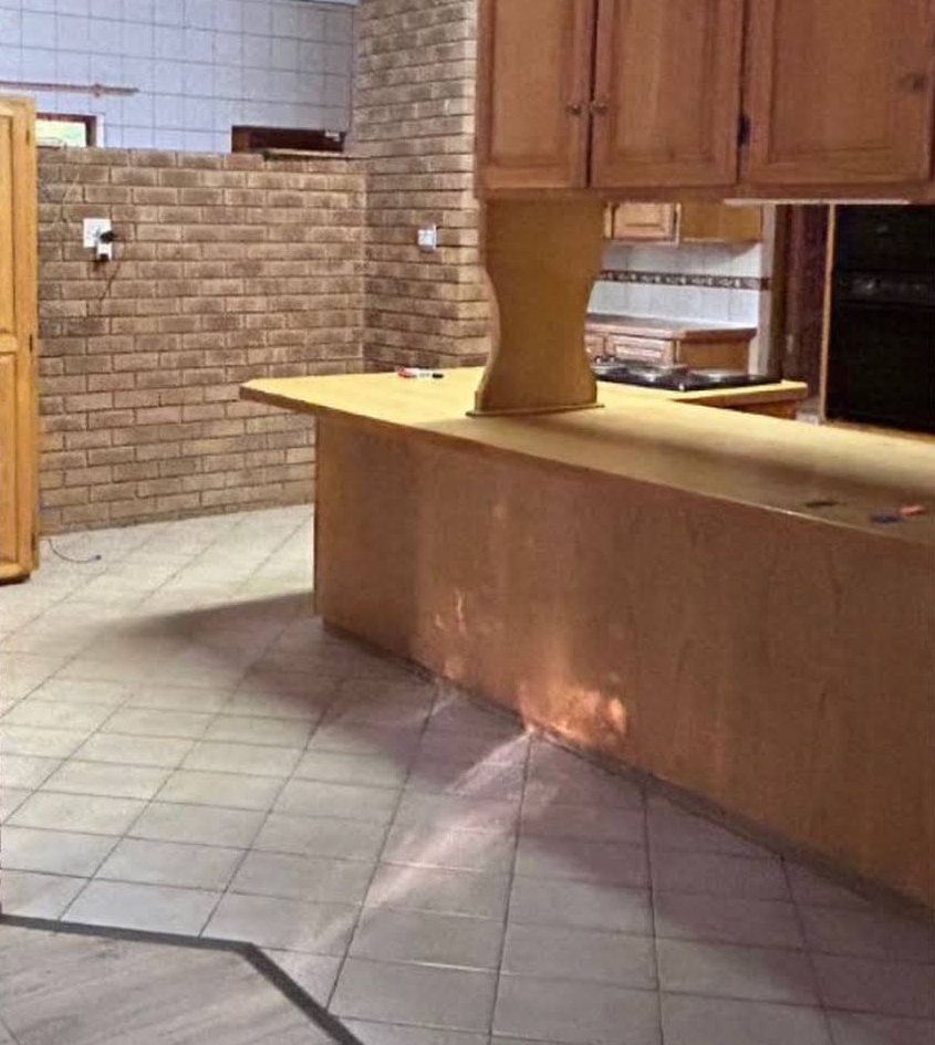 Before: kitchen with honey-coloured wooden cupboards and island