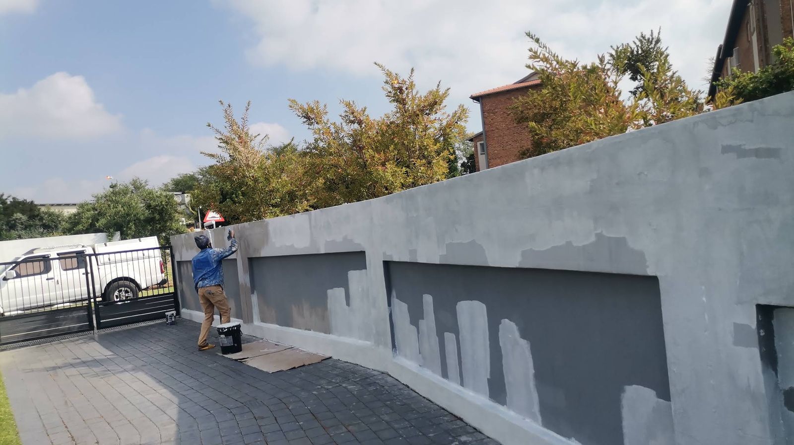 Boundary wall being primed along a driveway